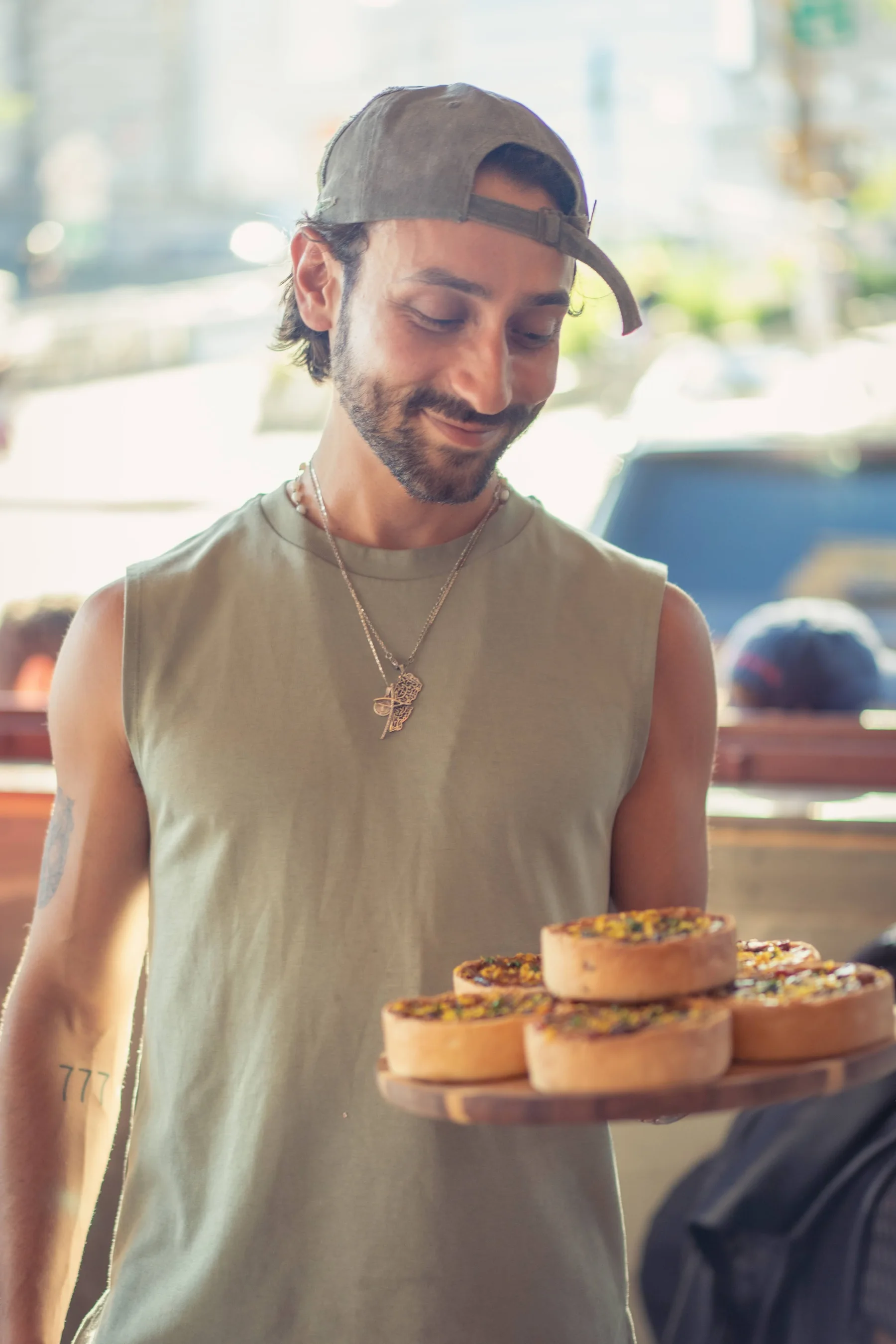 A La Méchante team member carrying a tray of freshly baked tartes